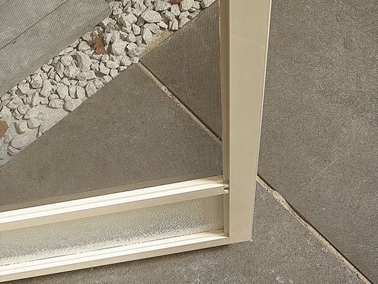 Przybliżenie narożnika moskitiery z białymi profilami aluminiowymi i siatką