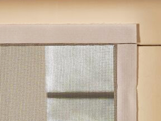 Fragment moskitiery zamontowanej na drzwiach za pomocą taśmy rzepowej